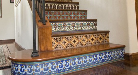 Hallway flooring ideas. HOUZ(N/D) tiled Spanish stair risers cover the stairs, use different patterned tiles to draw the eye towards the top of the stairs. The warm honey coloured tones of the wood flooring can be picked out in these tiles. 