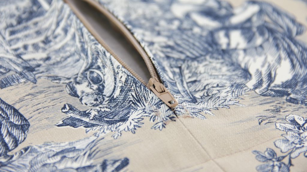 Close up detail of Nicoletta Perris Magnetto's soft furnishings cushion cover sample submission in a natural, Toile print with zip fastening by our Student of the Month, submitted as part of her Diploma in Curtain Making & Soft Furnishings work.