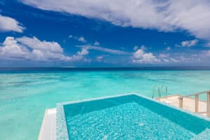 Minimalist infinity pool in tropical paradise beach. Luxury reso